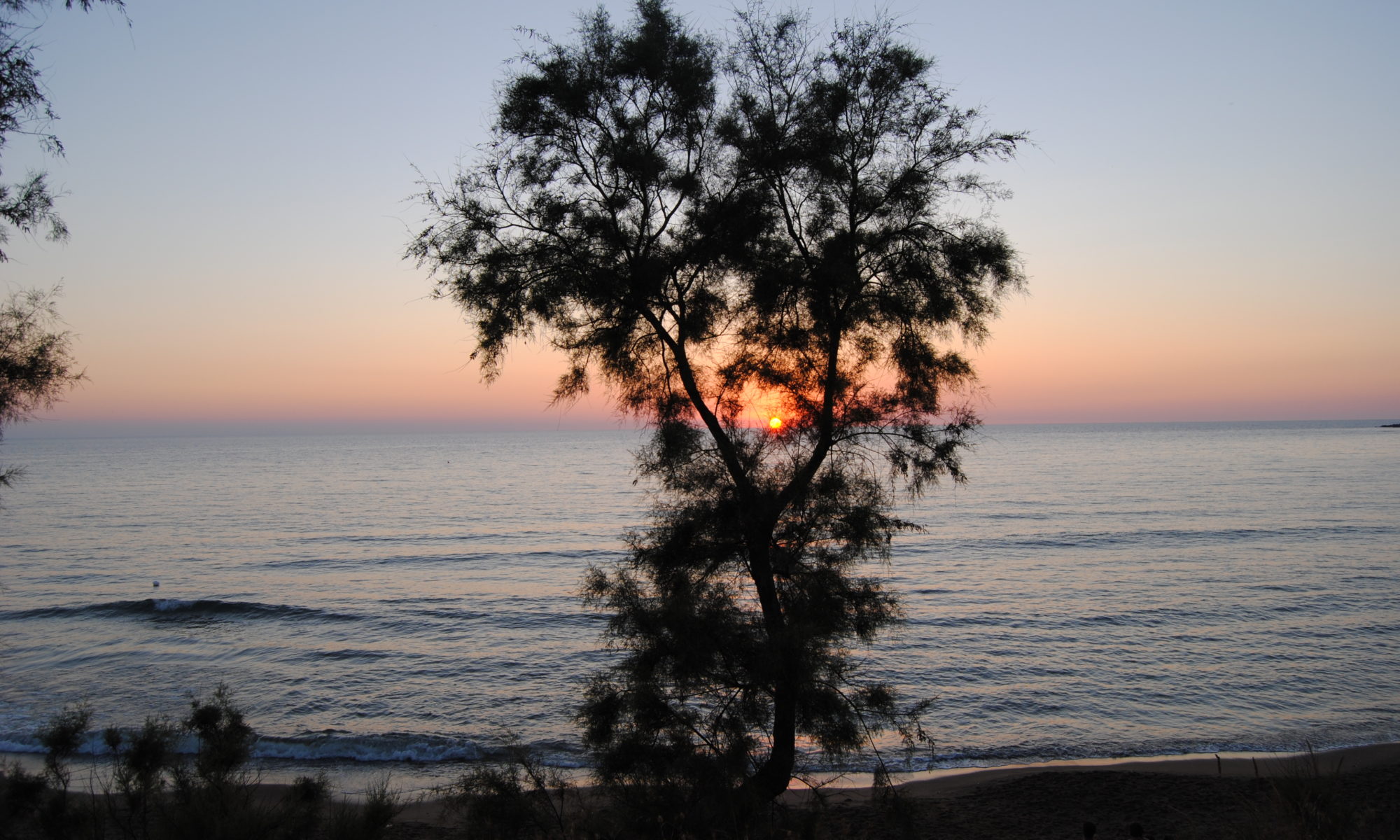 Suggestivo tramonto sul mare dal golfo di Baratti, in Toscana relativo ad articolo sulle stagioni