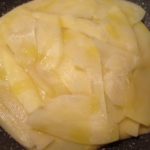 Patate affettate sottilmente per frittata di patate vegana