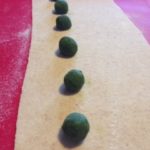 Preparazione dei ravioli alle erbette e fagioli, posizionando le palline di ripieno ad una certa distanza tra loro. Pasta preparata con farine integrali. Senza grassi animali