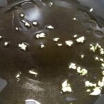 Prepariamo l'aglio a pezzettini e mettiamolo in padella con un filo d'olio extravergine d'oliva, pronto ad accogliere la nostra frittata senza uova